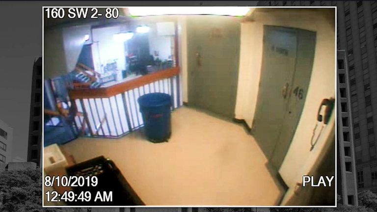 Screenshot of Epstein jail surveillance footage, as released by DOJ, showing grainy corridor view.